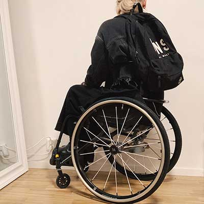 Ryggsäck på ryggen i rullstol